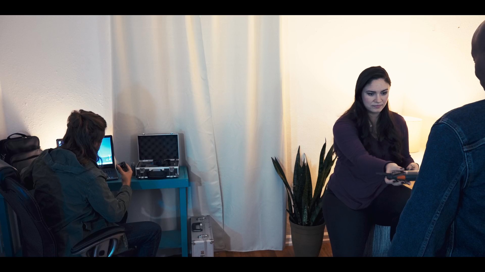 An aerial perspective transitions into a residential property, followed by a collaborative indoor scene involving individuals coordinating a production task.