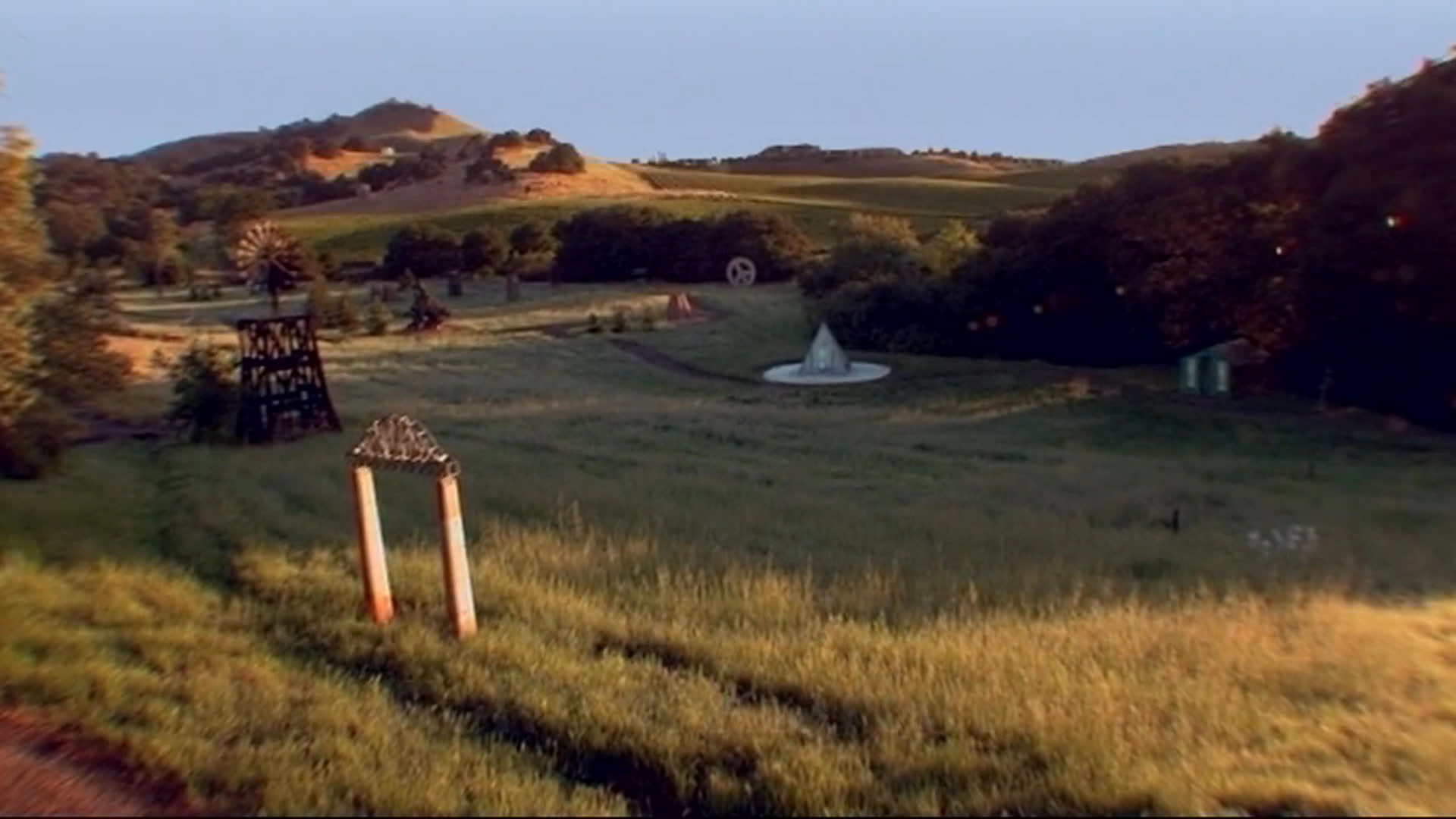 Golden light falls across rolling Napa hills as opening credits introduce the film and its creators. A small bottle house stands alone in the field, accompanying a reflection on the decision to build it.