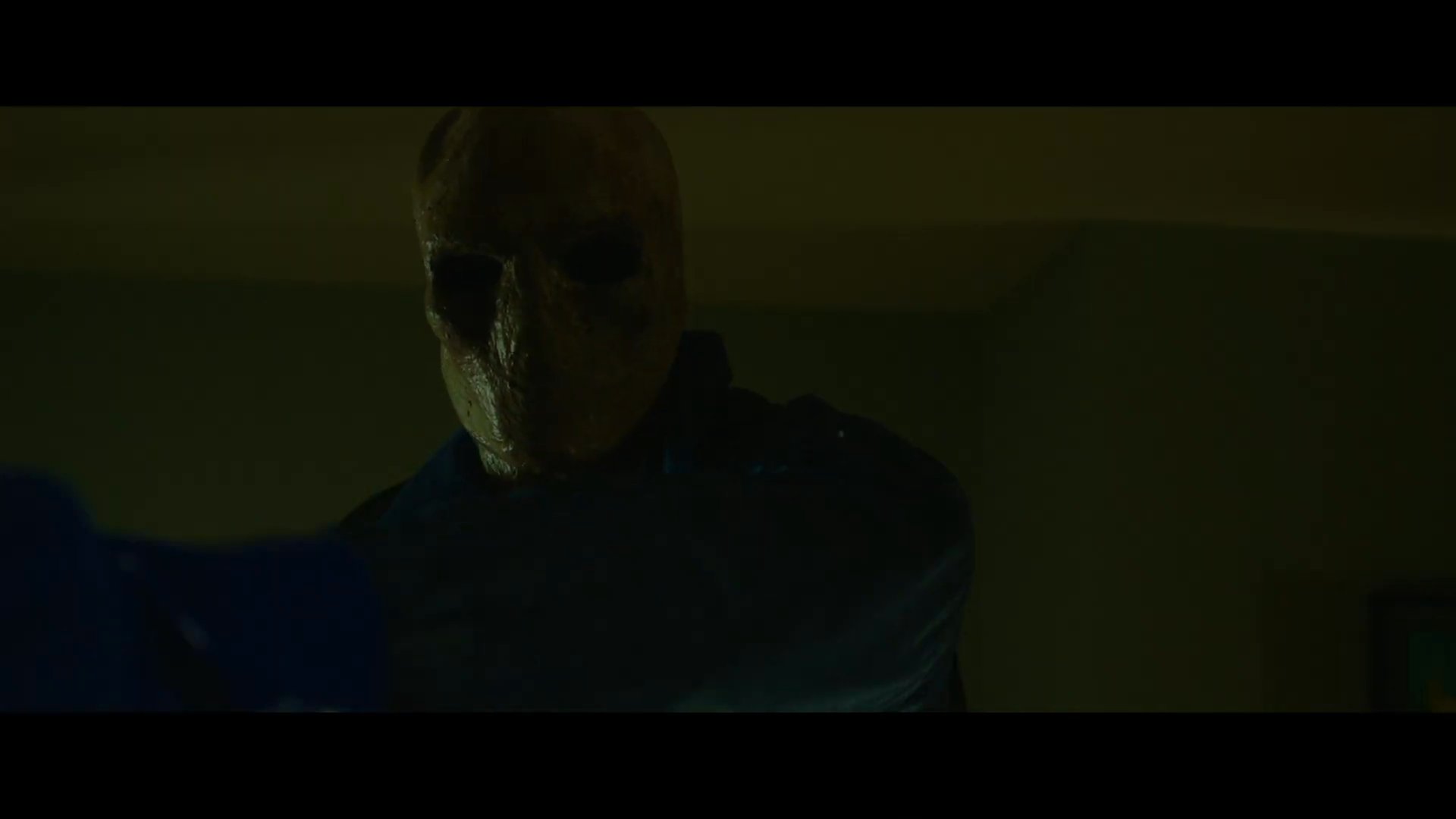 A masked intruder enters a bedroom at night, threatening a sleeping family while holding a firearm. The tension escalates as the man awakens to find the assailant looming over them.