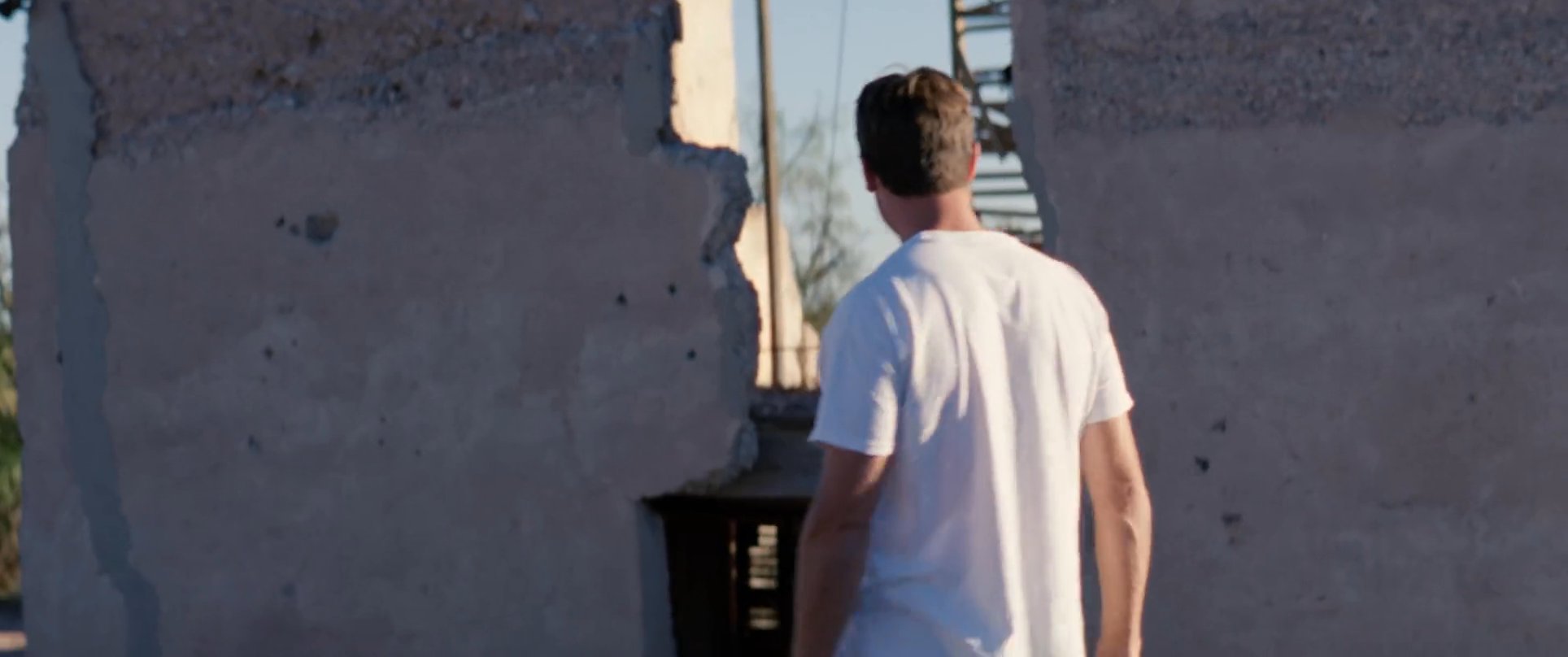 A man arrives by truck at a remote, dilapidated stone structure in the desert to survey the ruins.