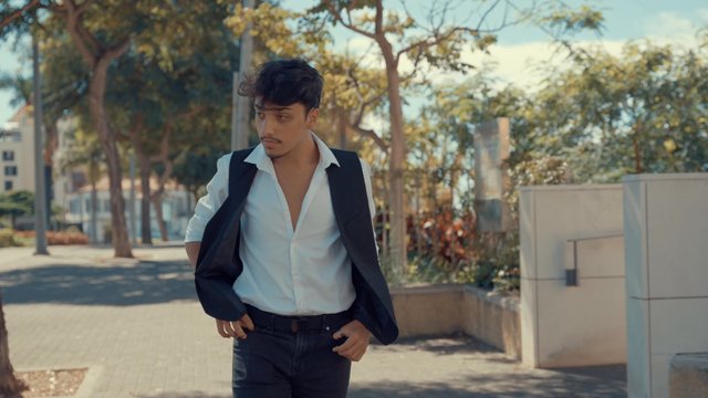 A man looking at his phone while walking around the city