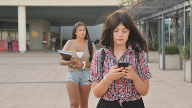 Students walking and texting on campus
