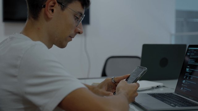 A guy is using a smartphone in his workplace
