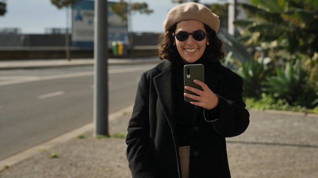 Woman filming with her smartphone on the street