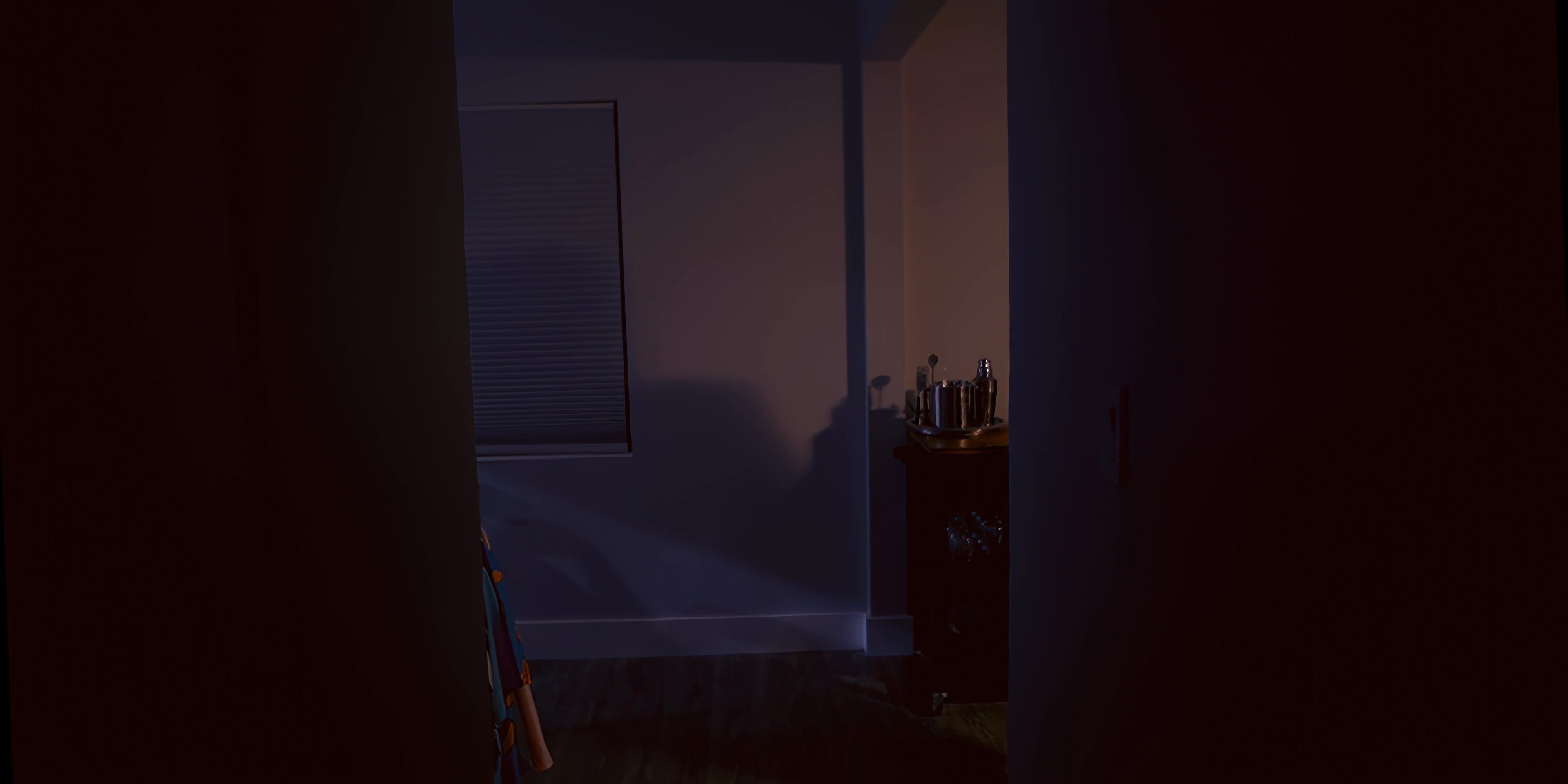 A man carries a meal through a dim apartment before settling into a recliner to pour a drink and relax in the evening.