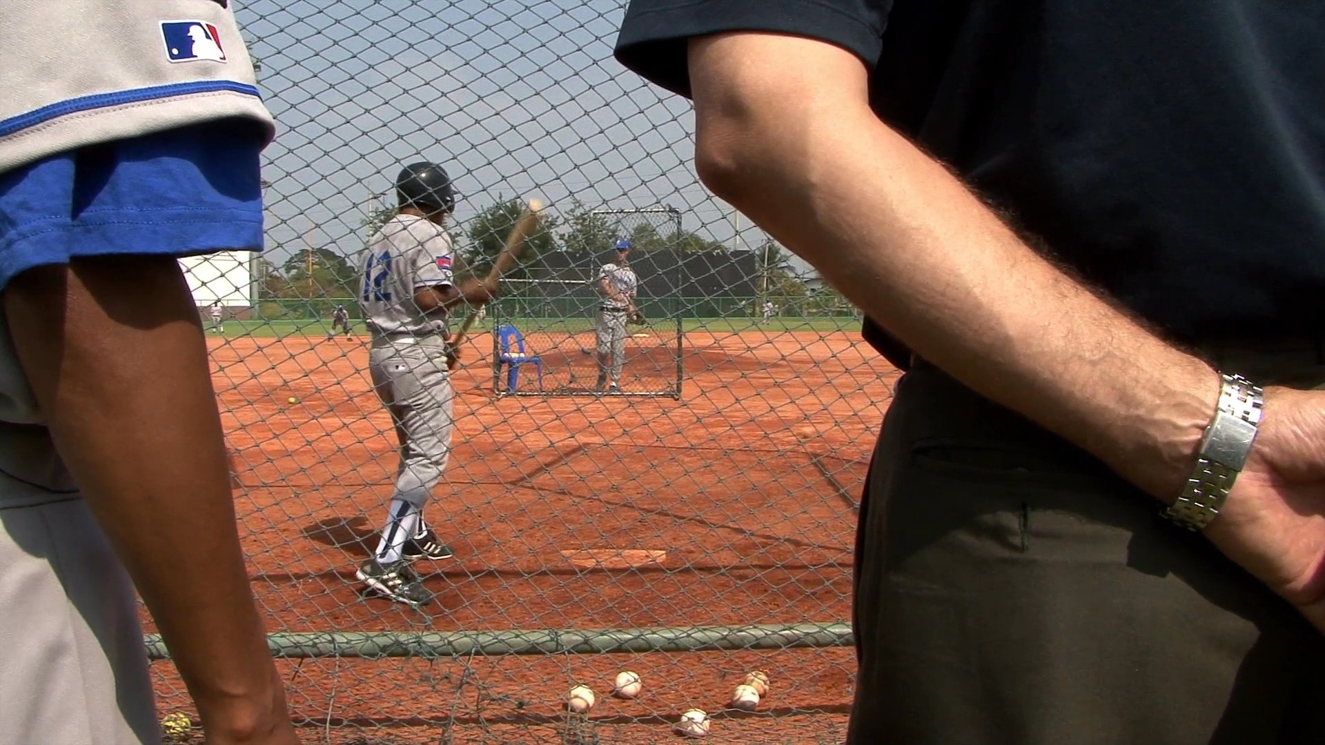 MLB representatives observe youth baseball training sessions and discuss development initiatives in Cambodia. The footage documents the collaborative efforts between international league officials and local coaching staff to improve athletic performance.