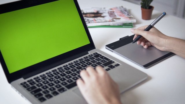Designer drawing near laptop