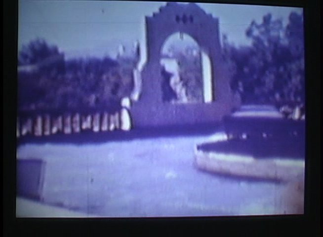 Patrons enjoy recreational activities at an amusement park and beach resort. The sequence highlights water attractions, roller coasters, and sunbathers along a coastal property.