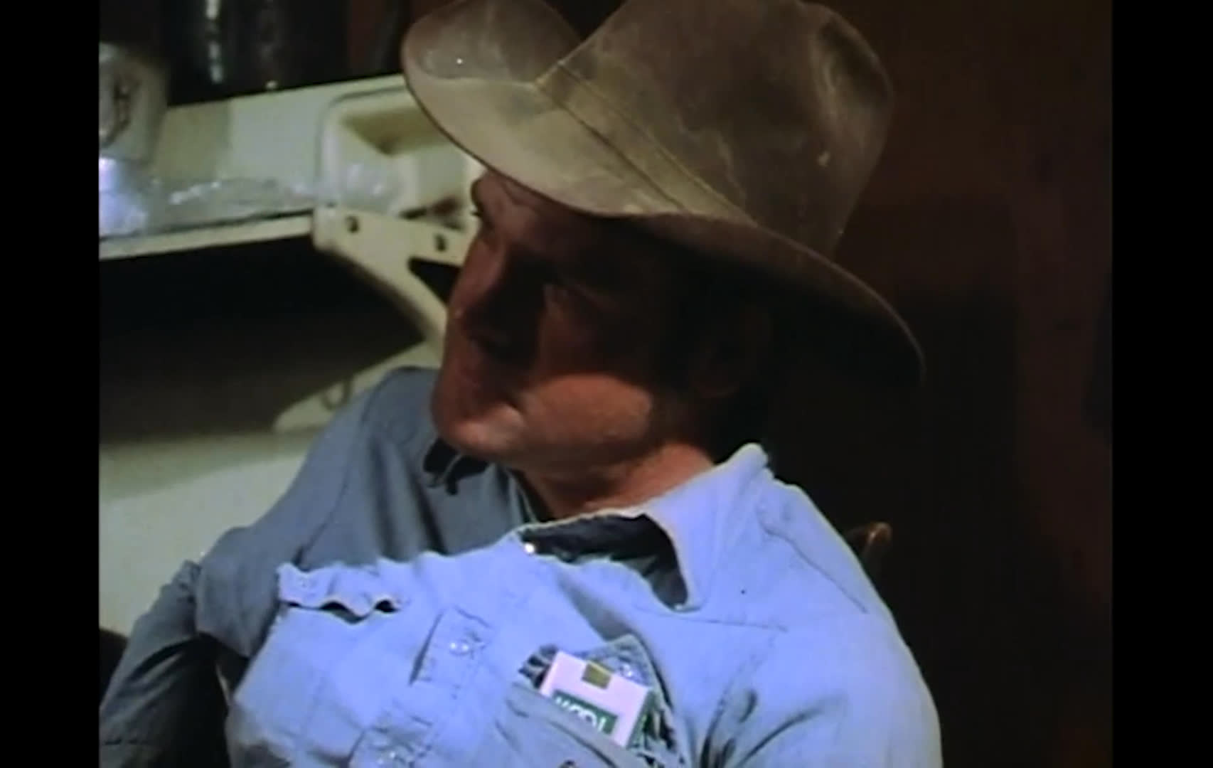 A man in a wood-paneled office discusses the difficult choice between responding to growing public demands and protecting the people whose businesses may be affected by resource reductions. Several older men in cowboy hats listen in separate shots as he reflects on compassion and hunger.