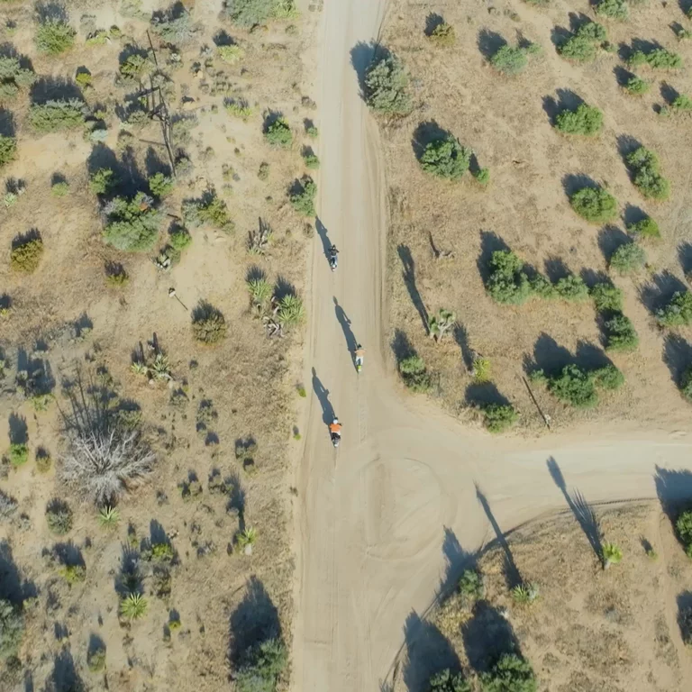 Aerial view of motorcyclists riding through desert landscape