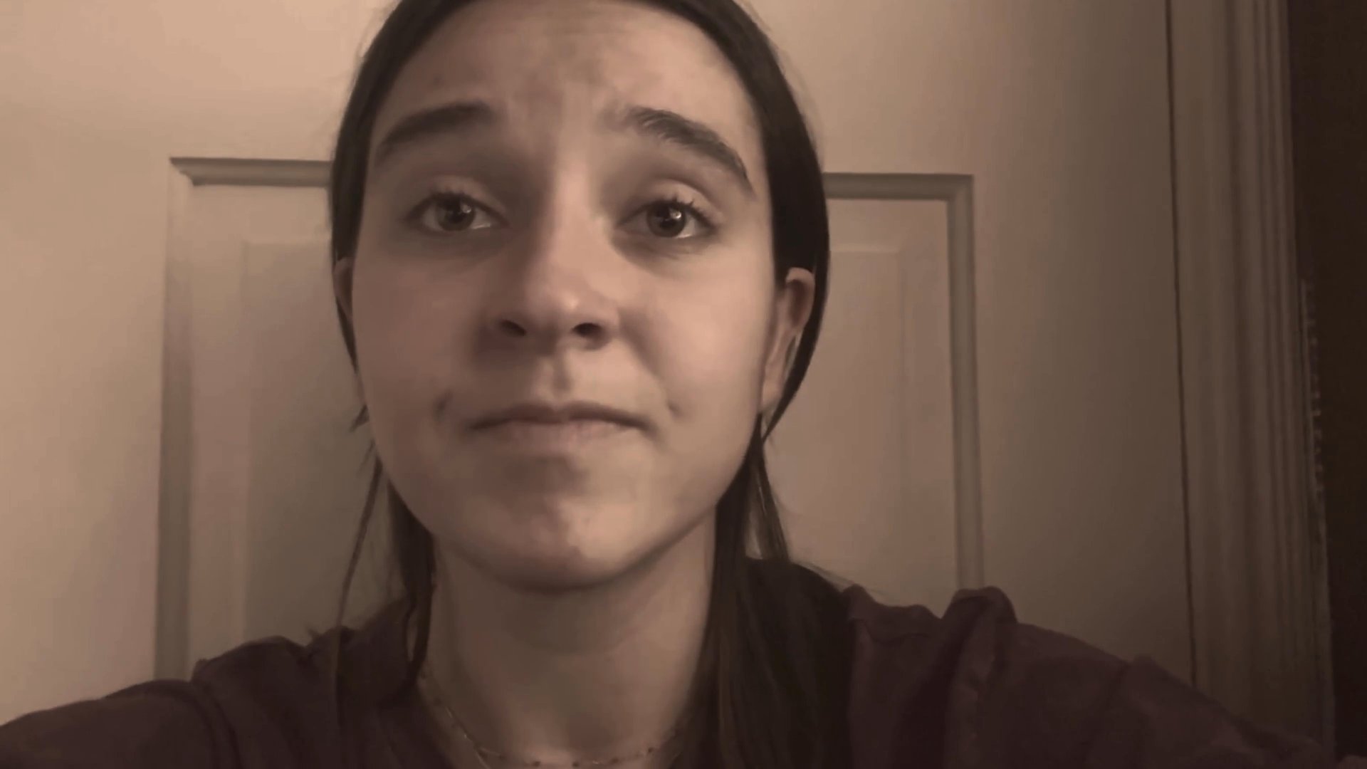 A young woman addresses the camera directly in a candid, introspective monologue, sharing personal thoughts and reflections from an indoor setting.