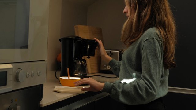 Una niña pone un filtro en una máquina de café