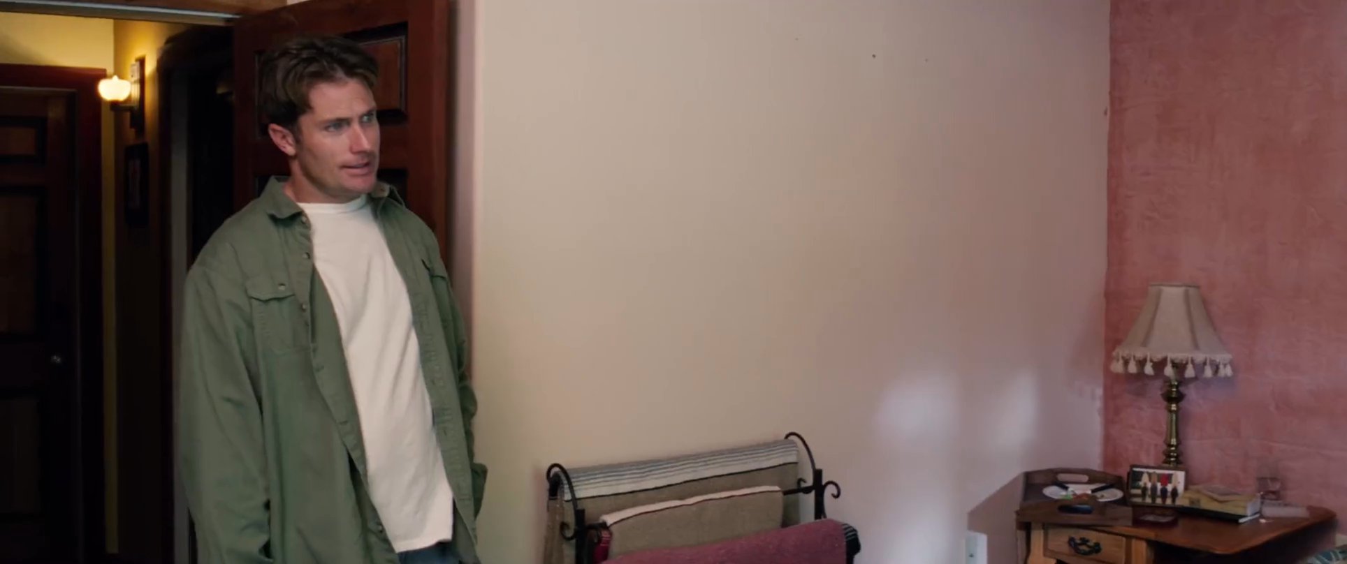 A tense encounter unfolds as two men engage in a serious discussion within a bedroom setting. The exchange highlights a moment of interpersonal conflict and significant narrative weight.