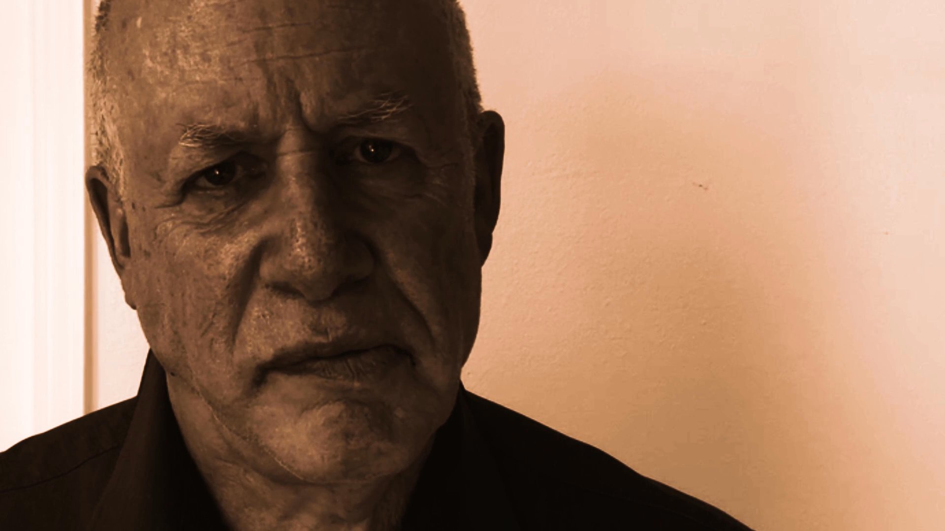 A mature man addresses the viewer directly, sharing thoughts or observations in a continuous, conversational tone against a neutral background.