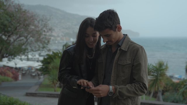 Una pareja mira algo en un teléfono inteligente