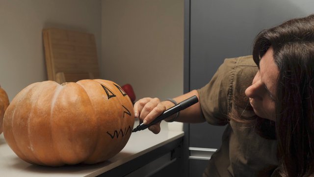 Drawing a mouth on a pumpkin