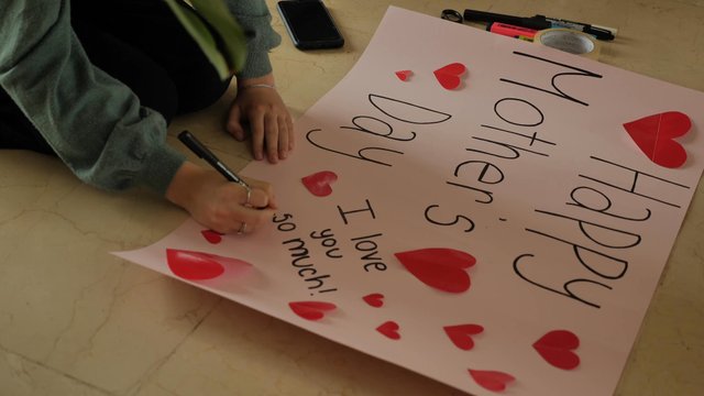 Writing a message on a Mother's Day poster