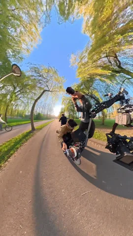 Ein Filmteam richtet Kameras an einem Kran auf einem von Bäumen gesäumten Weg ein.