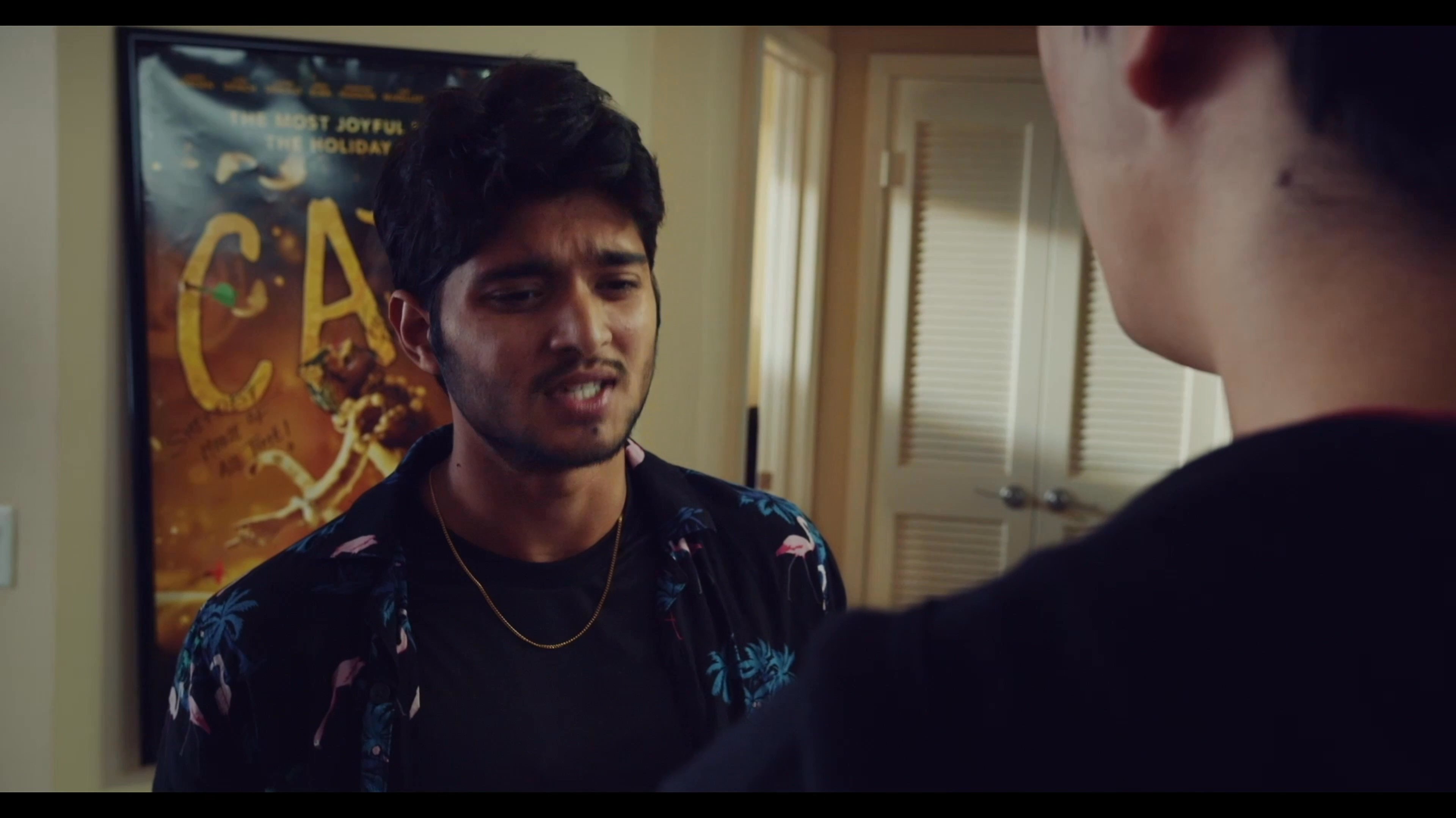 Two young men engage in a tense conversation within an apartment setting, navigating a disagreement through direct verbal interaction.