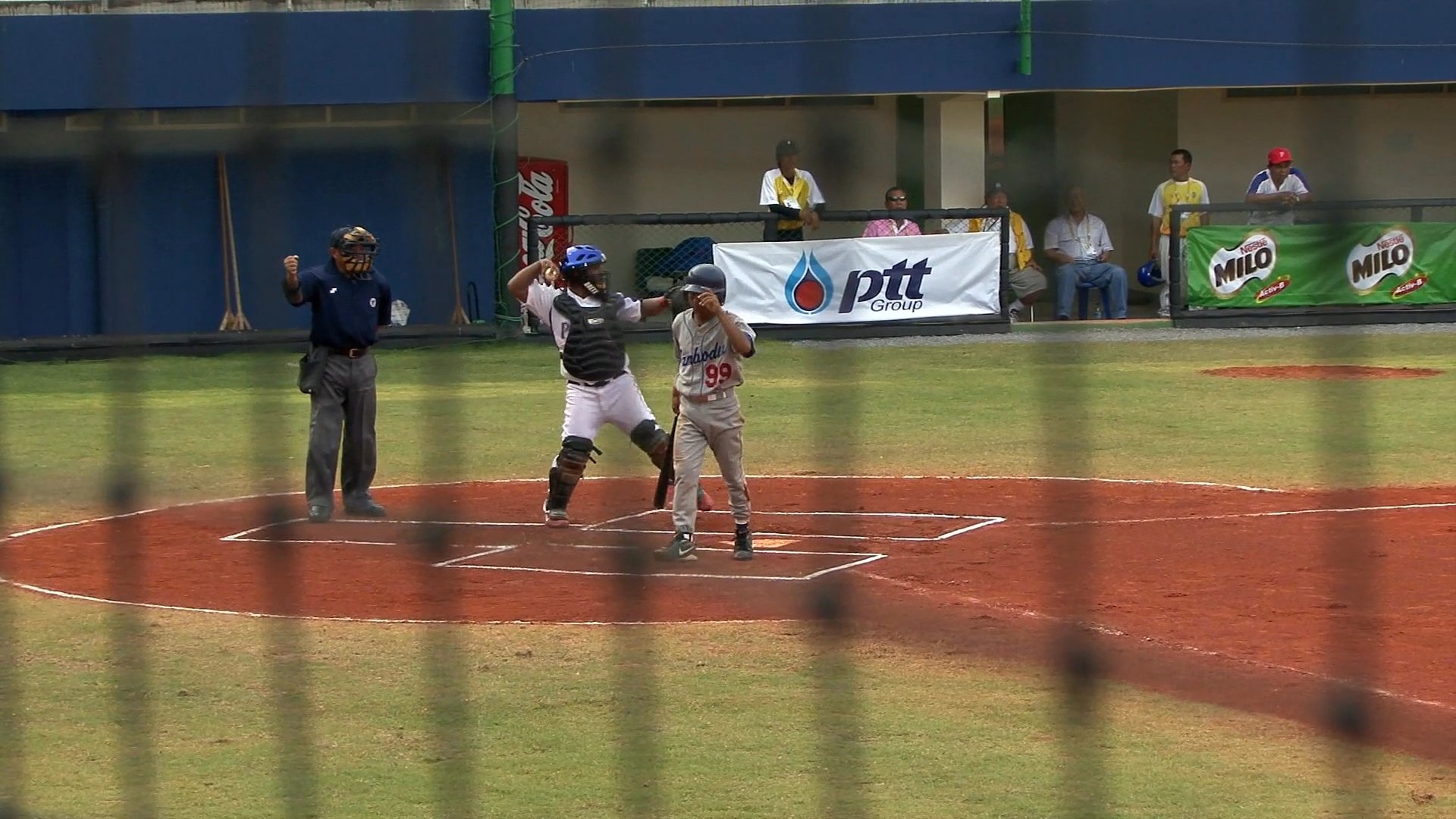A baseball game unfolds between Cambodia and the Philippines, featuring pitchers and batters in active competition on a professional field. The scoreboard tracks the ongoing progress of the match throughout the innings.