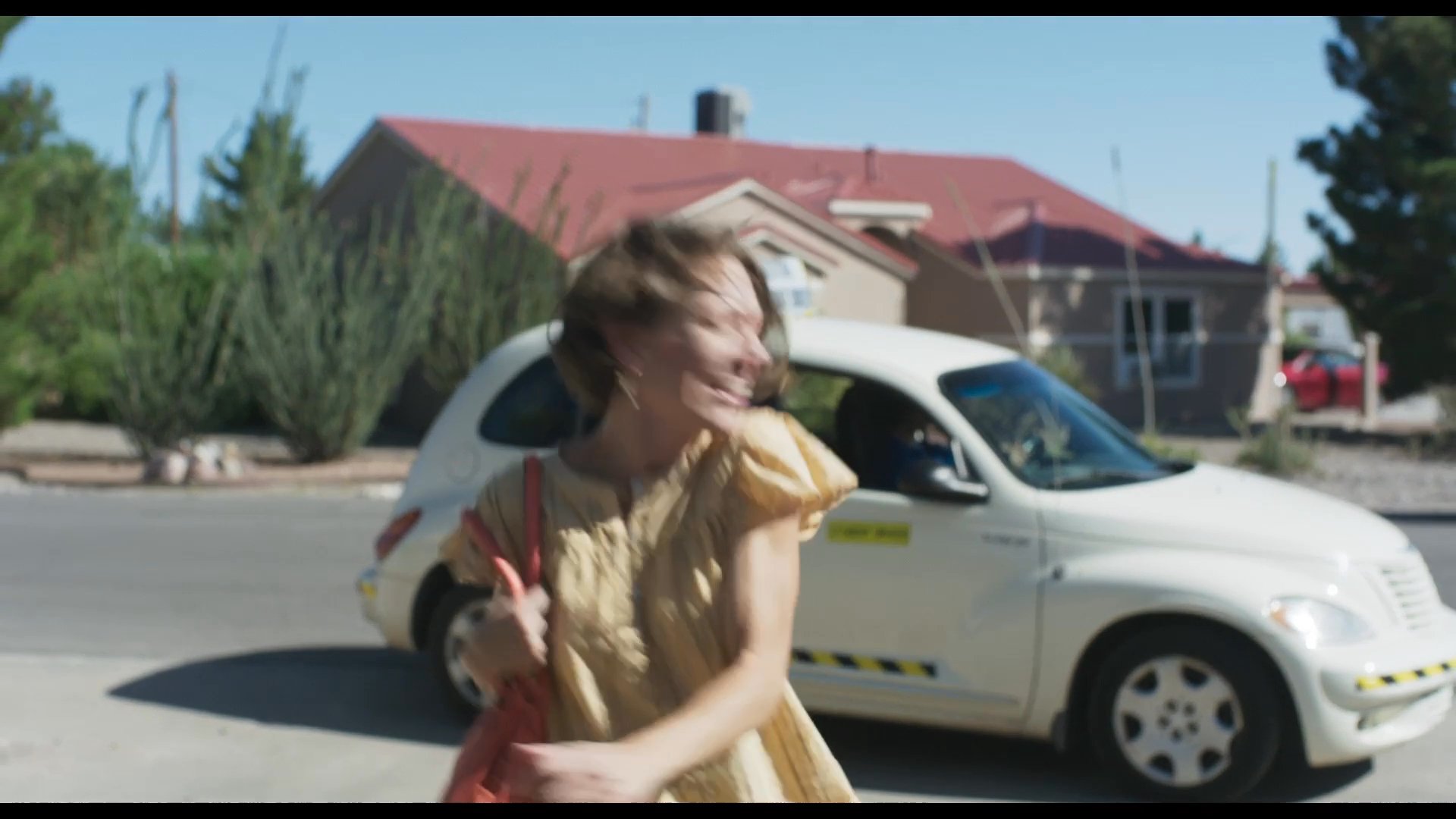 A woman arrives at her home in a taxi and enters the house with excitement and anticipation. She moves through the interior space, clearly eager to be back.