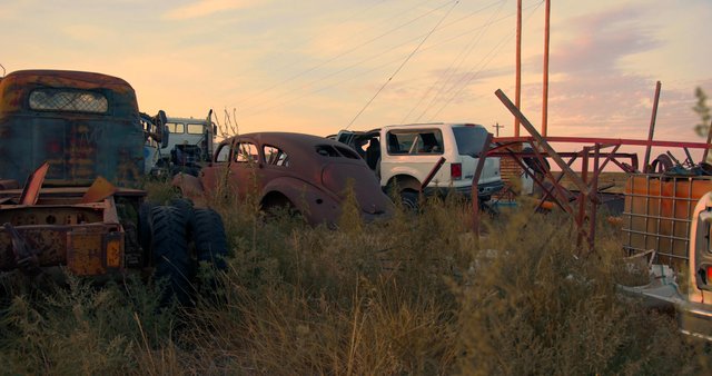 Old cars at a scrapyard in the sunset