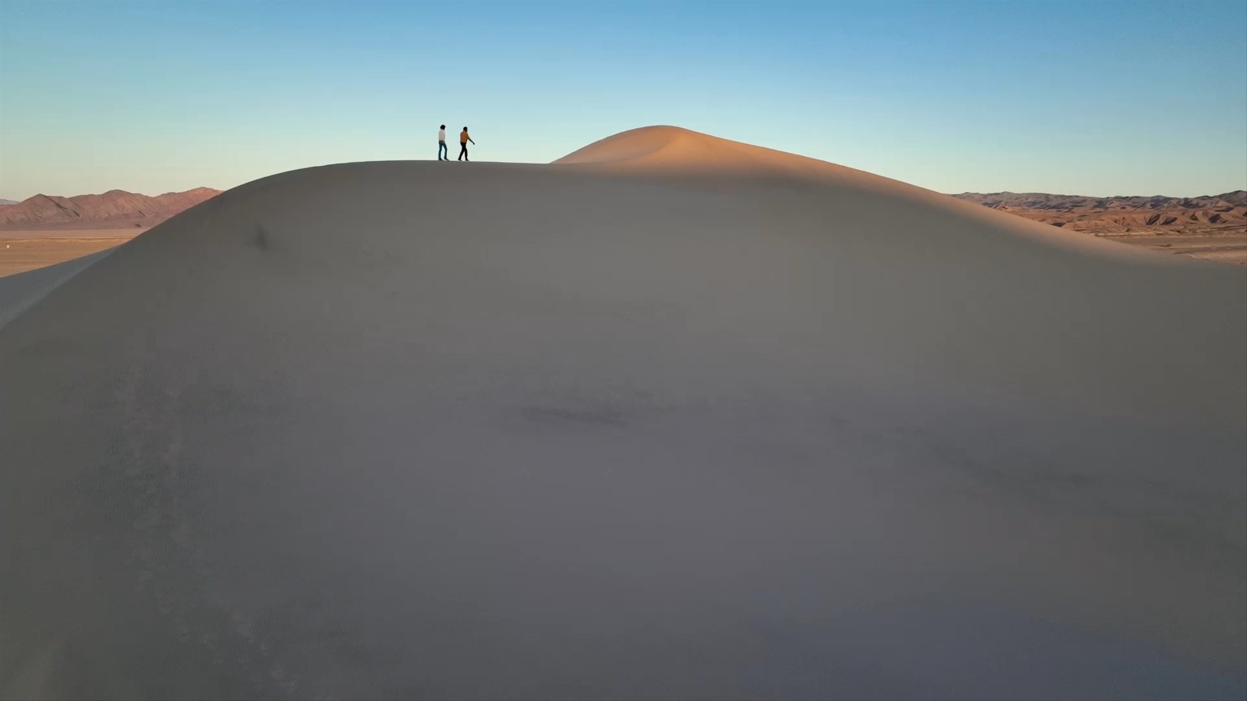 Video of man and woman walking on sand dunes