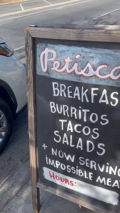 Petiscos - Street sign in front walk into small relaxing space to sit and chill after ordering your food. Walkway to restroom. - Tacos Near Me - Claremont, California
