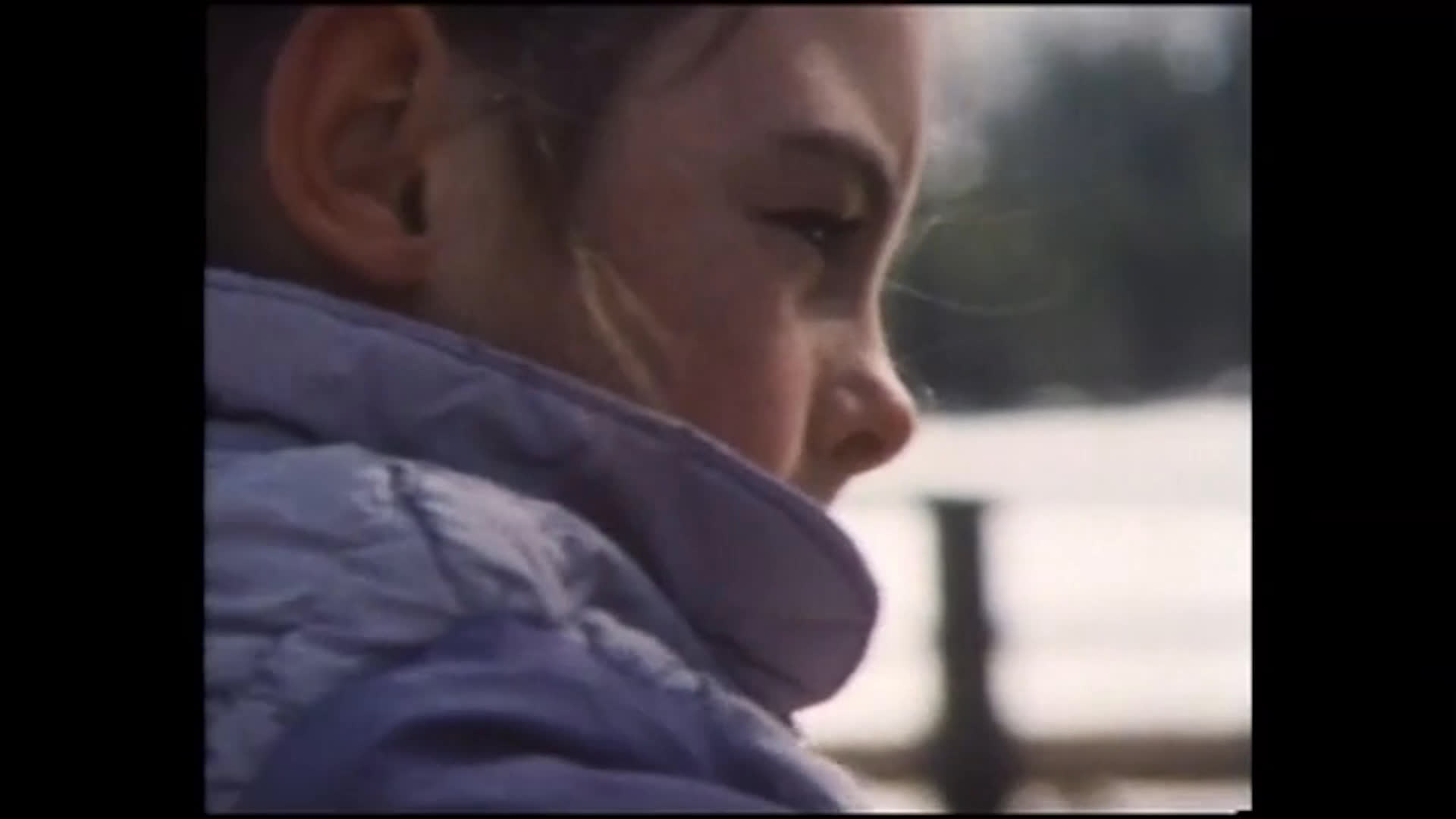 A young woman in a purple jacket gently handles a horse and its bridle in a fenced, snow-dusted paddock. The narration describes her as compassionate and says she hopes to become a nurse or veterinarian.