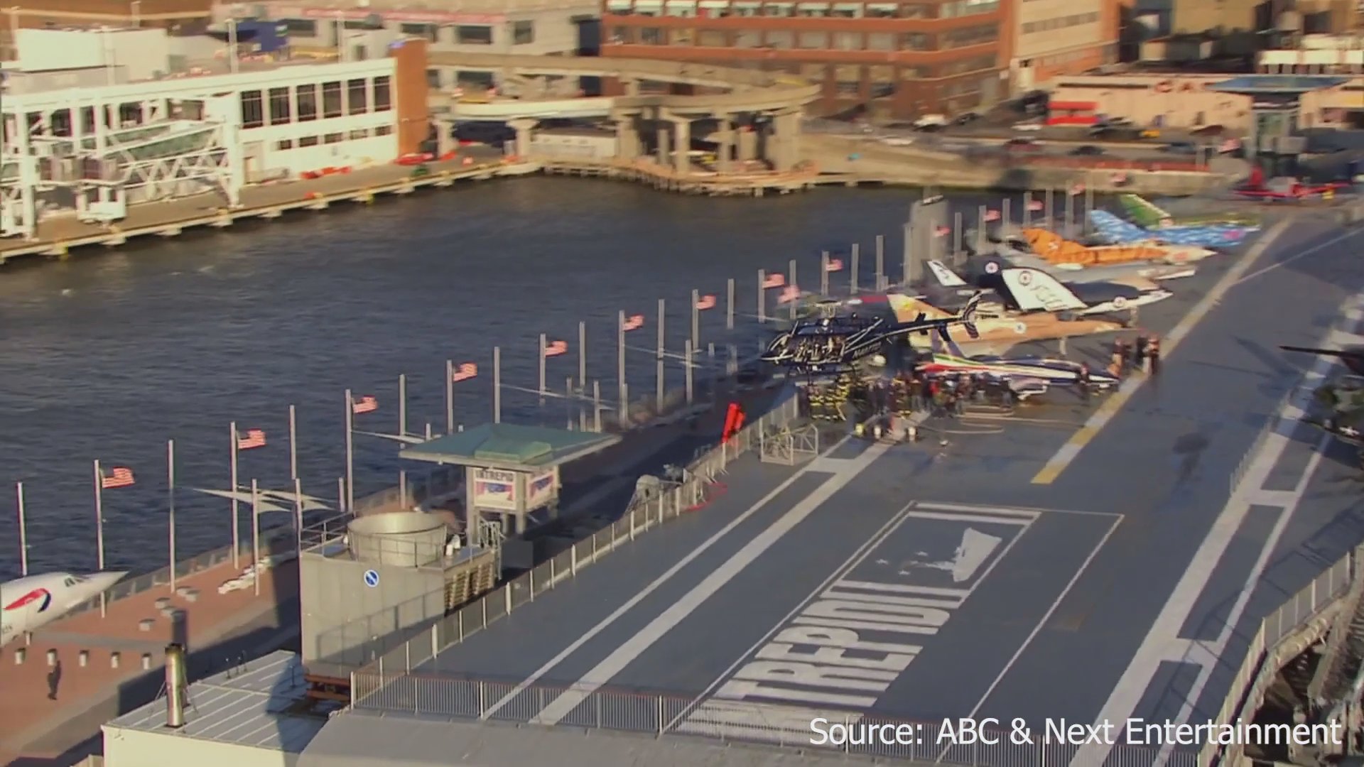 A man and a woman take an aerial helicopter tour over the Intrepid Sea, Air & Space Museum and the New York City skyline.