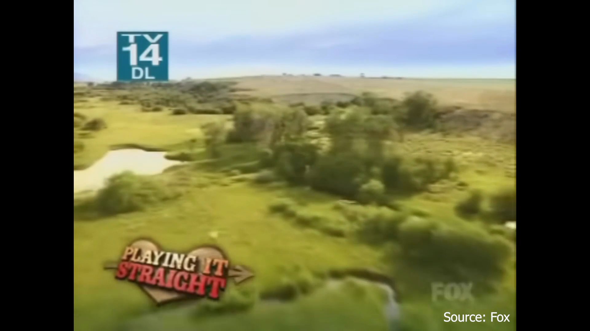 Aerial footage sweeps across a vast rural landscape toward a mountain backdrop before transitioning to a woman walking outdoors and a group of men arriving on a gravel path.