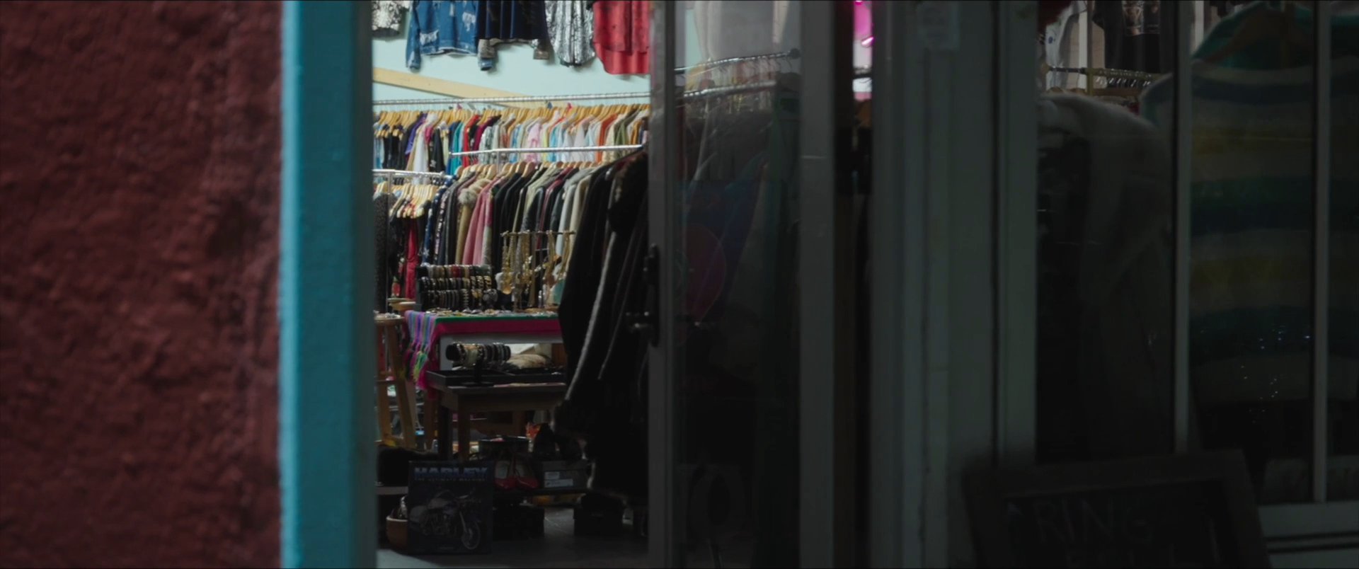 Two individuals engage in a reflective conversation before browsing a clothing boutique, where they examine apparel and discuss their selections.