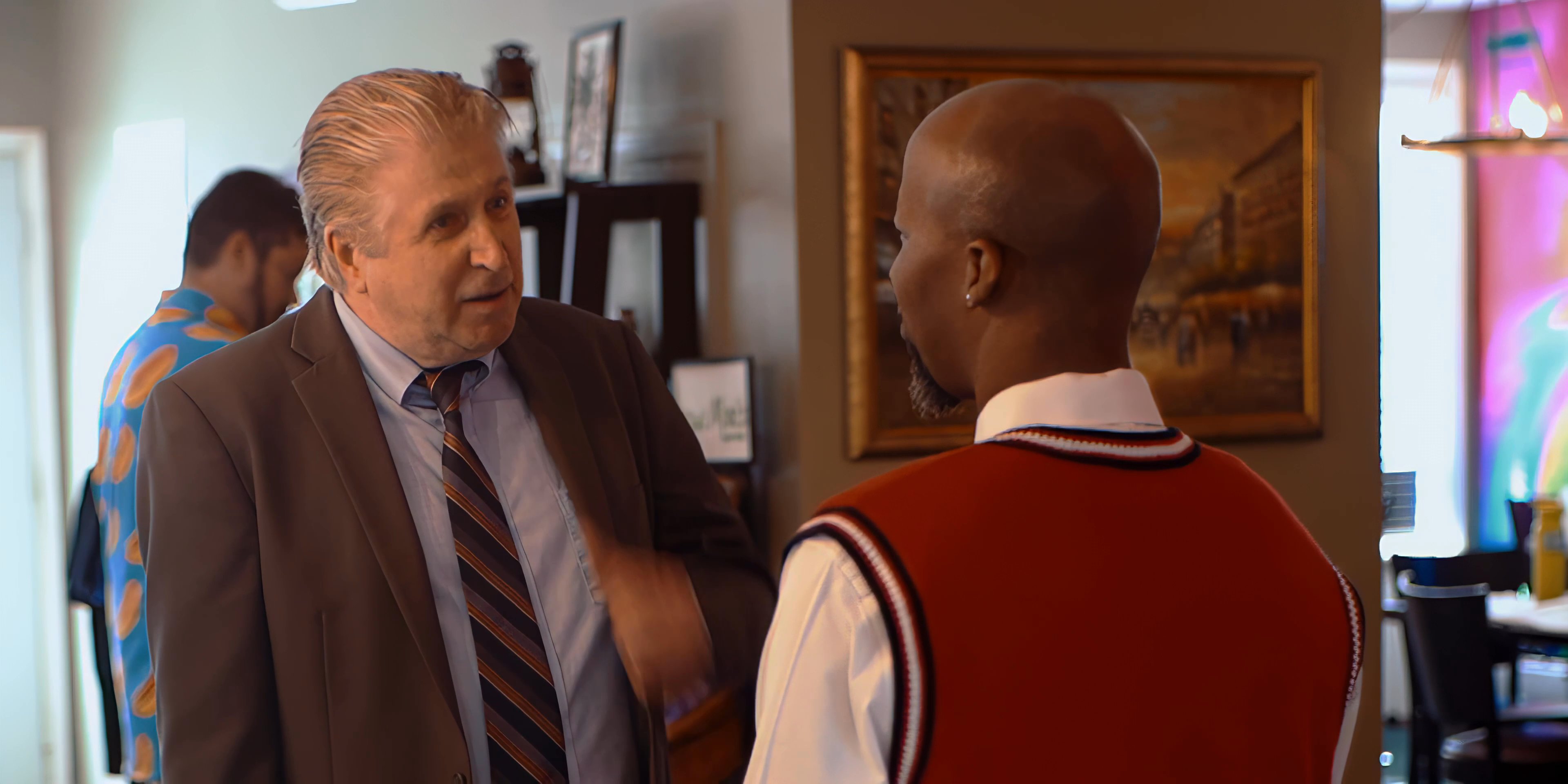 Two men engage in a professional discussion and negotiate within a retail environment. The interaction concludes with a mutual agreement as they exchange a handshake.