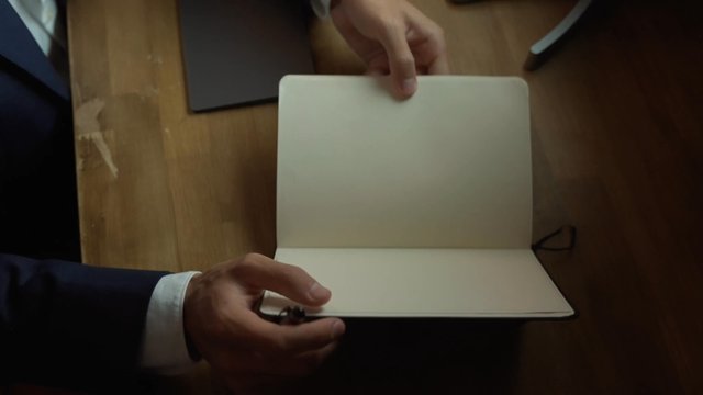 A man flipping pages in a notebook