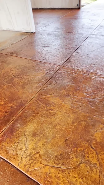 Stamped concrete with acid stain in variegated brown and amber tones