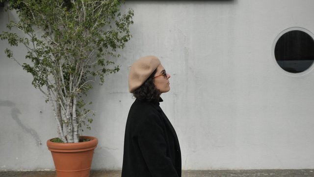 Woman walking past a white building