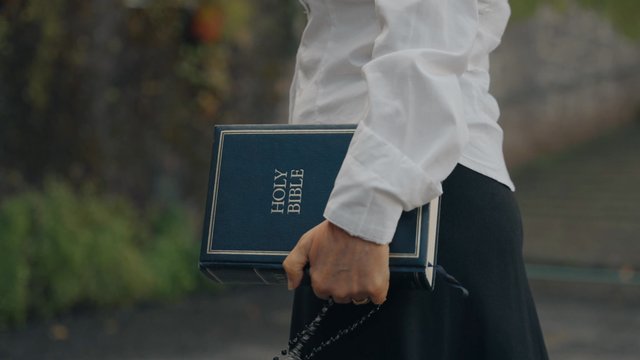 Una mujer religiosa lleva una santa biblia.