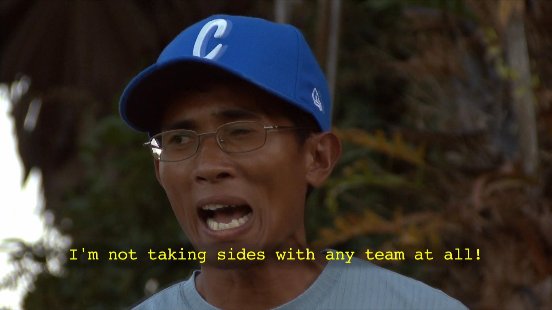 A coach addresses a group of young baseball players on the field, emphasizing the importance of effort and sportsmanship. The team gathers together, fostering morale and focus after a practice session.