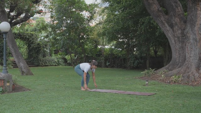 Yoga teacher rolling a yoga mat up