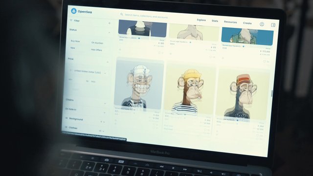 Person browsing the OpenSea marketplace on a laptop