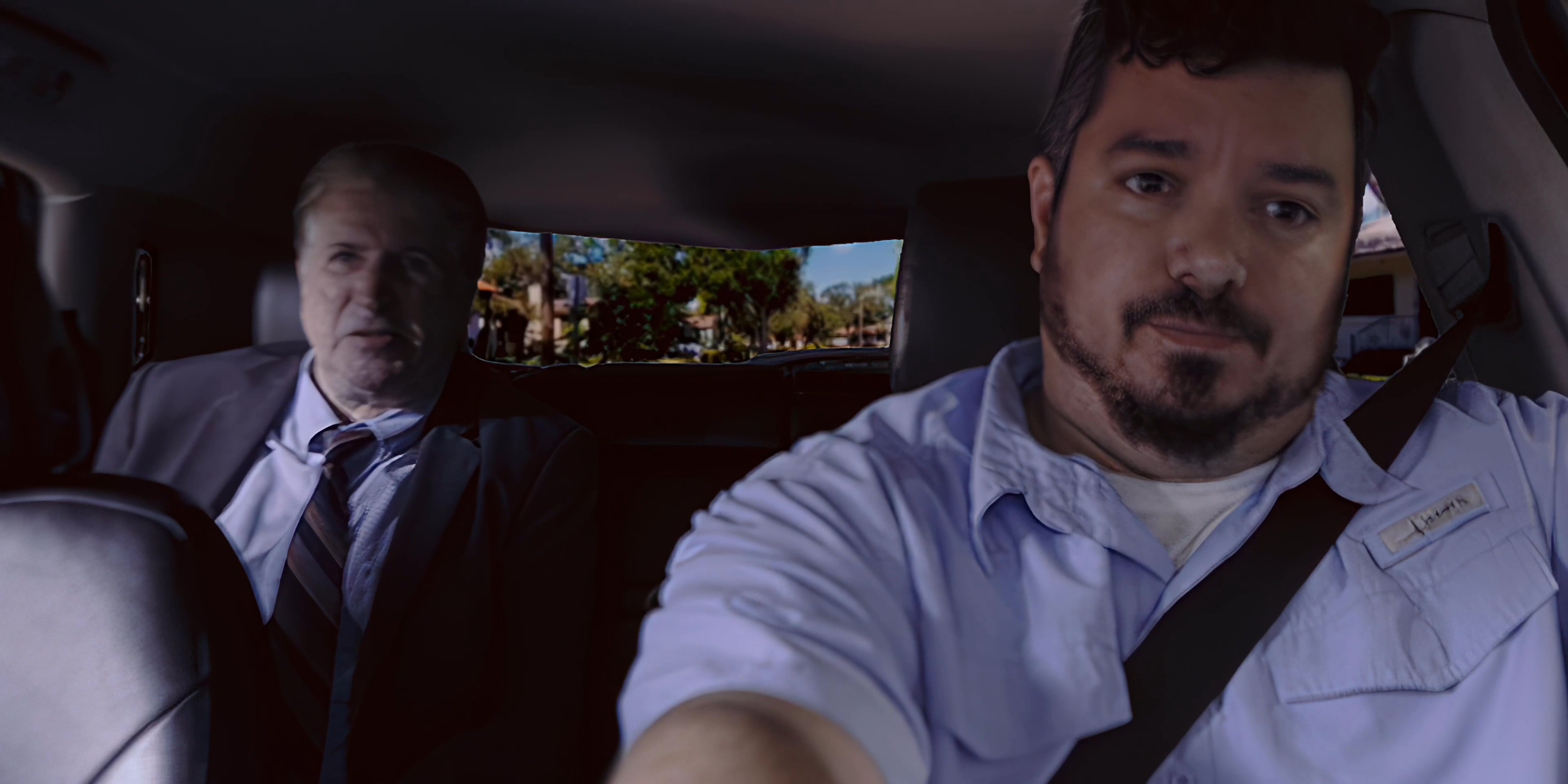An employee driving a vehicle engages in a focused discussion with a passenger wearing a suit. The two individuals maintain eye contact and interact throughout the duration of the ride.