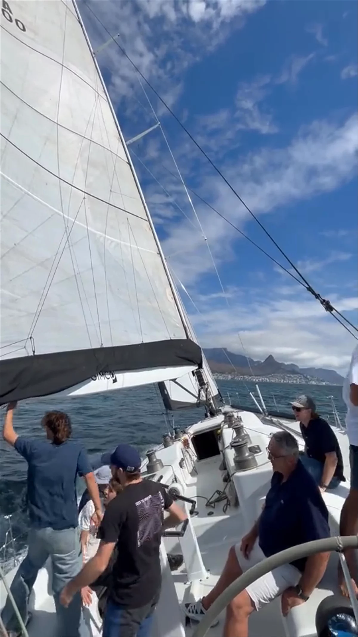 Crew on Warrior's deck under full sail, Table Mountain behind