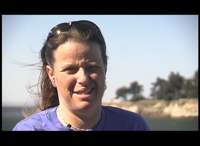 Individuals discuss ocean conditions and surfing techniques before demonstrating their skills on the waves. The footage captures both an informative interview segment and active surfing footage.