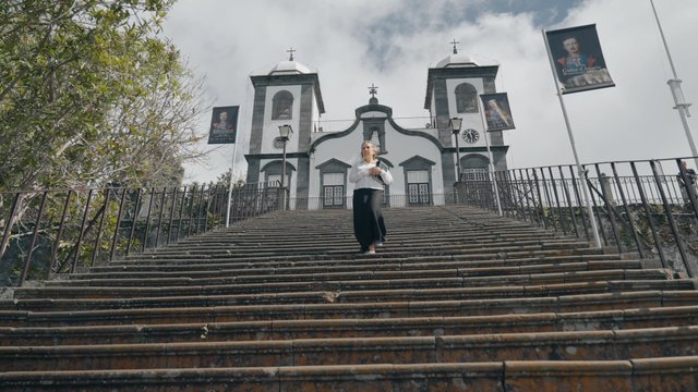 A woman walks down the stairs from the church