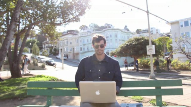 Man puts away his laptop and reads a newspaper
