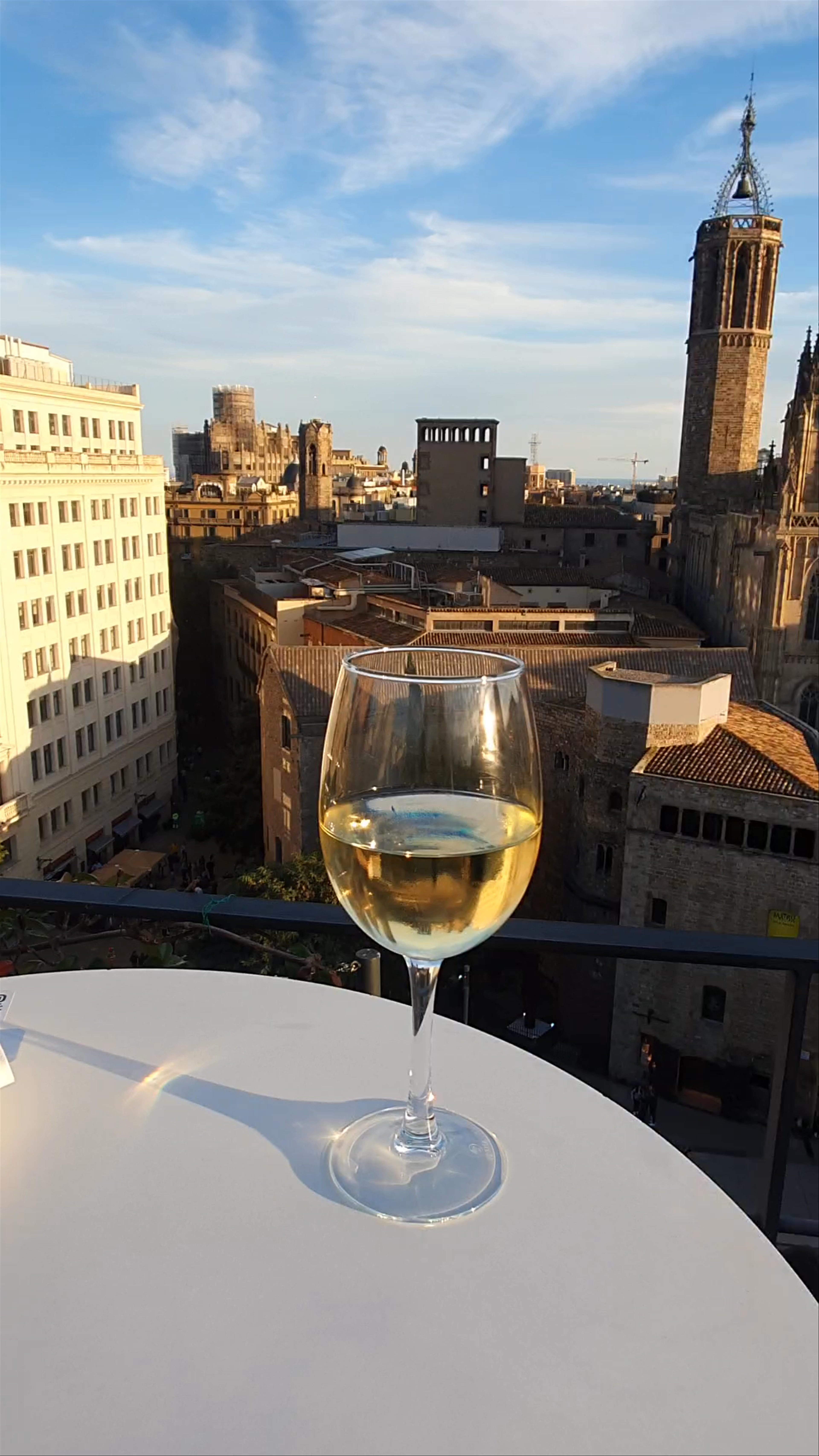 Sunset Serenity: Rooftop View of Barcelona Cathedral with Glass of White Wine
