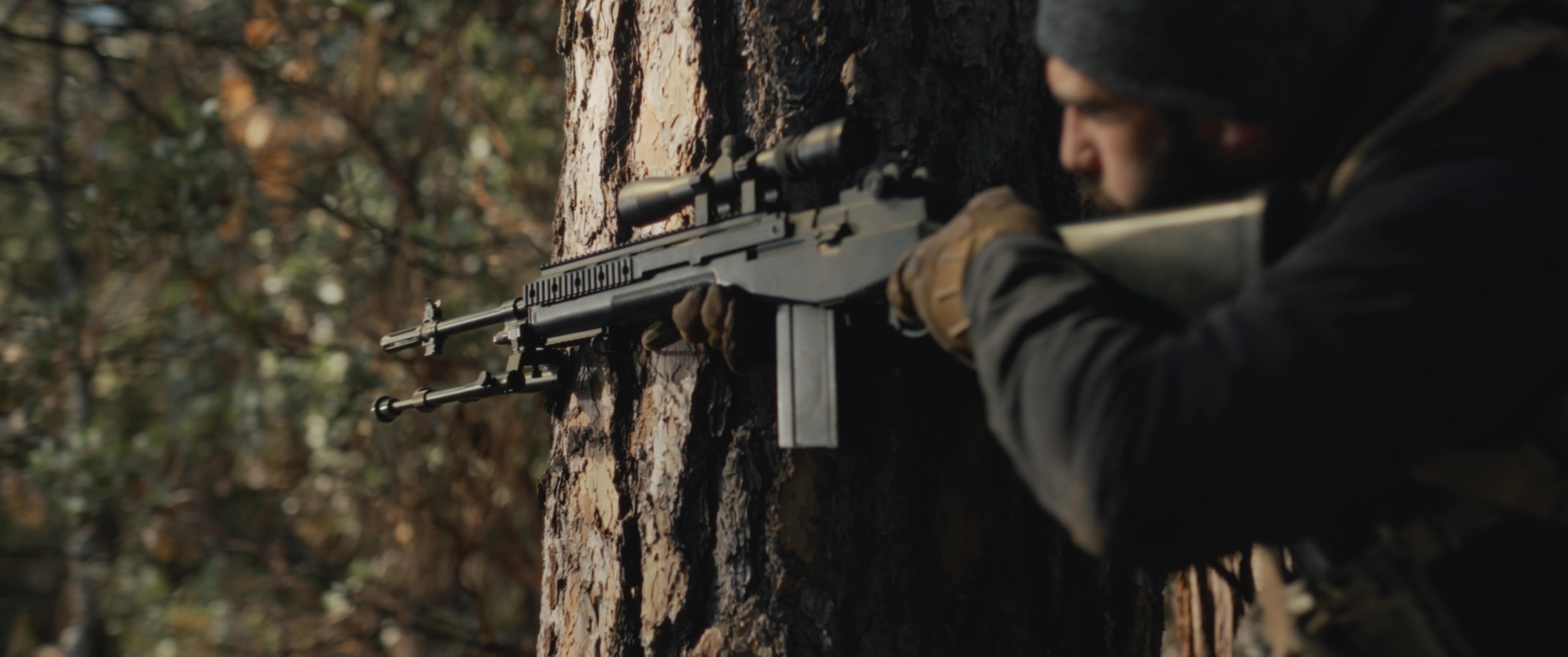 A tactical marksman maneuvers through a forested environment, utilizing trees for cover while operating a scoped rifle. The sequence concludes with a tense standoff against an opposing figure in a cowboy hat.
