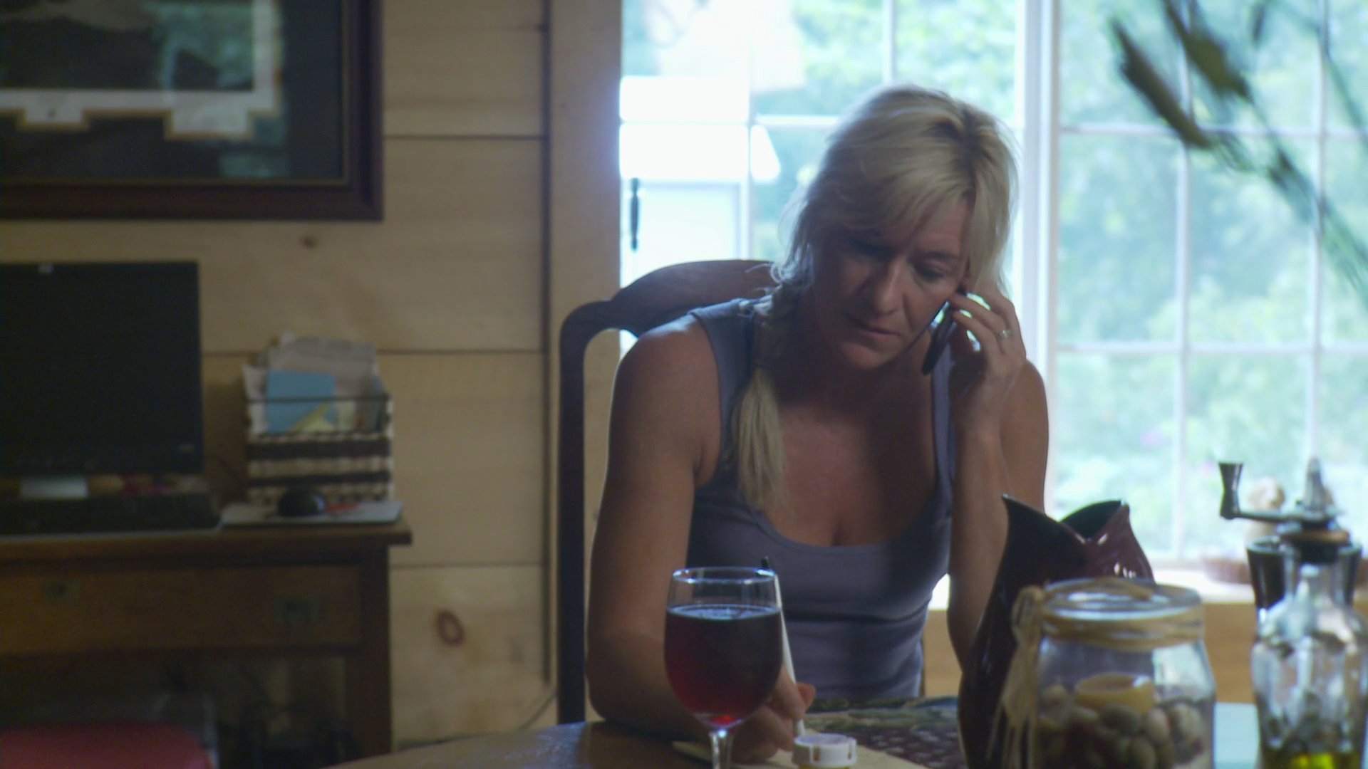 Two individuals engage in separate, professional telephone conversations within residential work environments. They maintain active communication while seated at their respective desks.