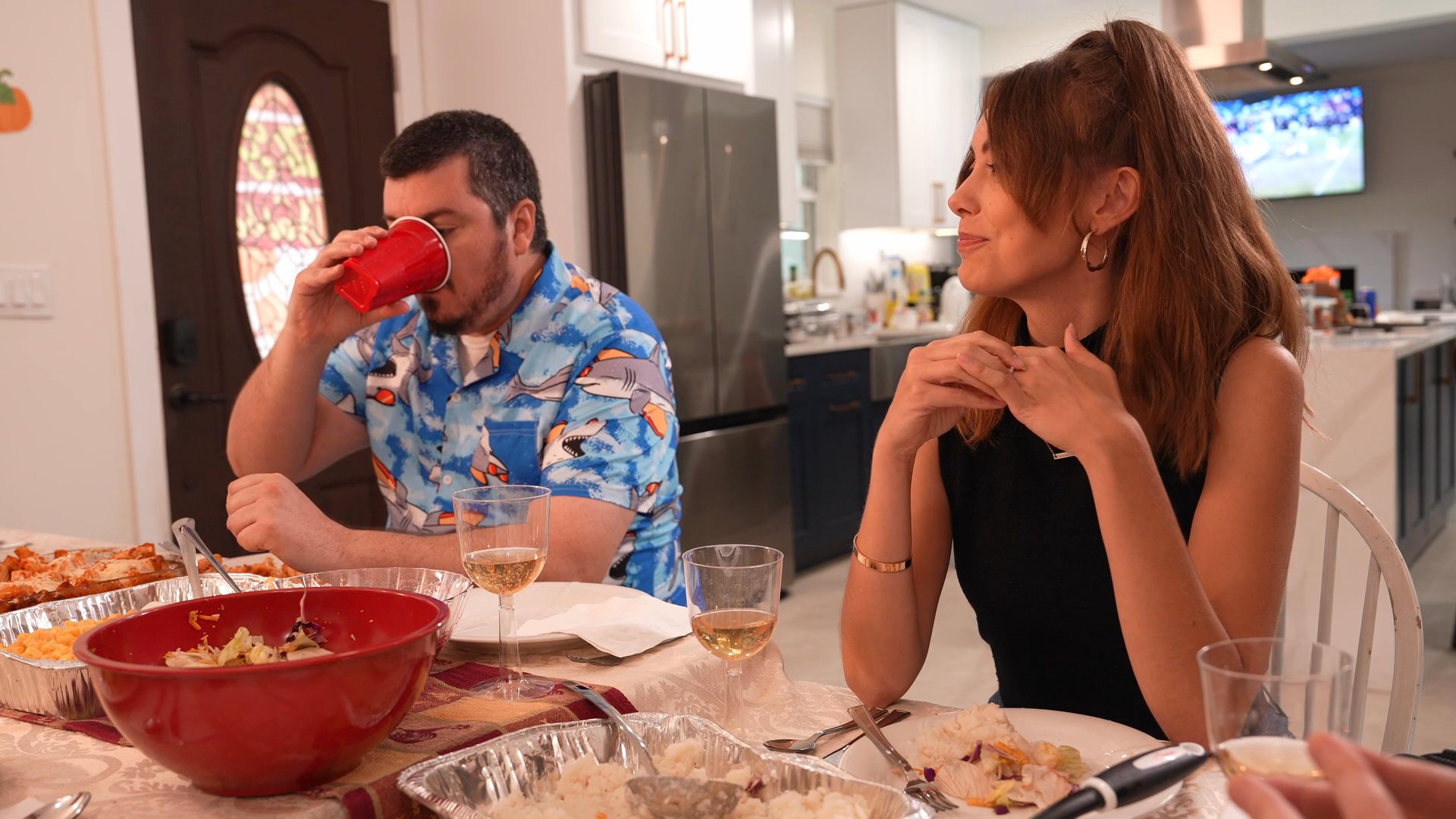 A diverse group of friends and family gather around a dinner table to share a meal, exchange conversation, and raise their glasses for a toast.