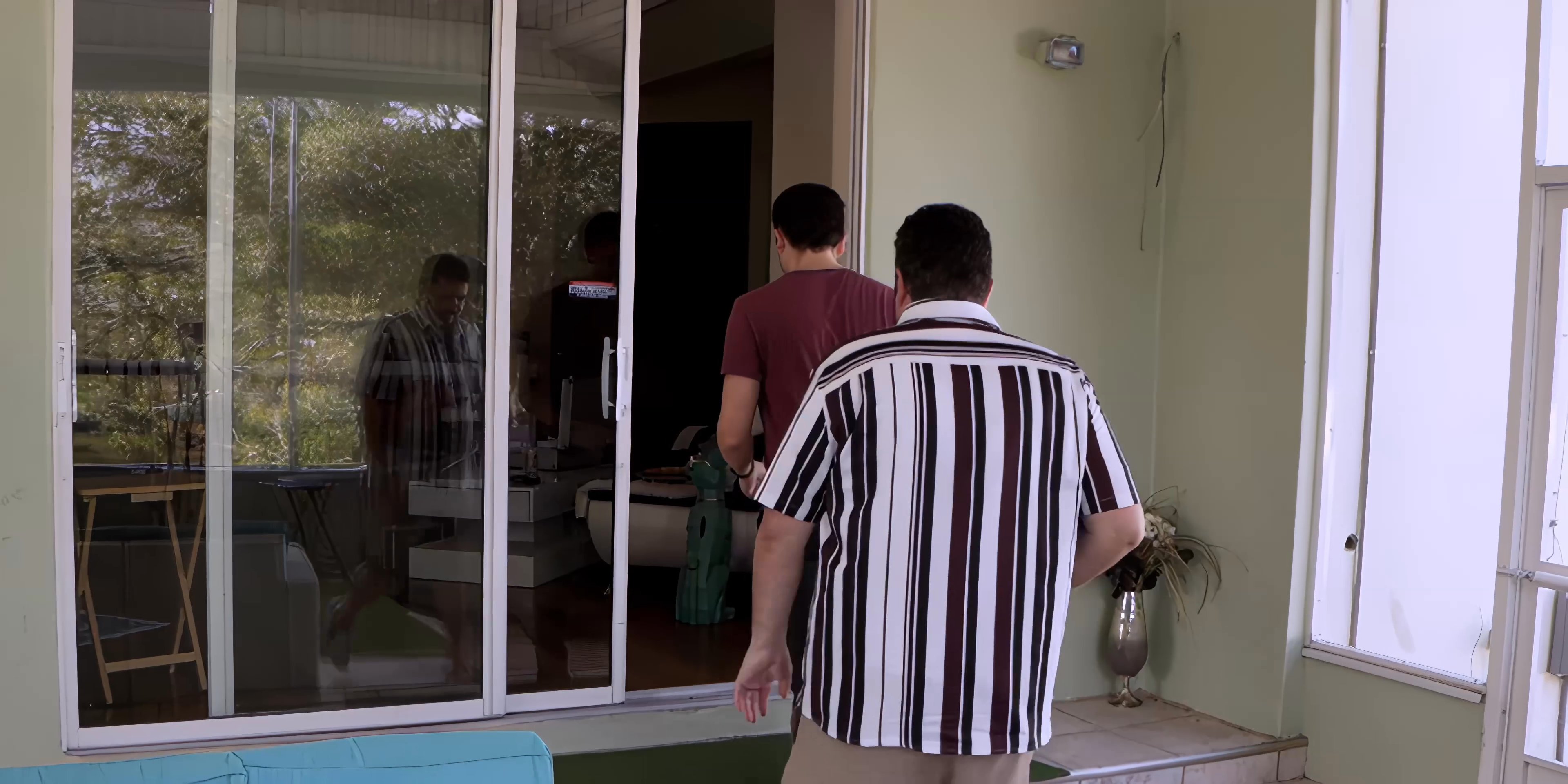 A group of colleagues or acquaintances converse on an outdoor patio before some members depart, leaving two individuals to continue their dialogue.